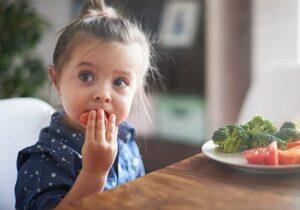 small female child enjoys nutritious snack in feeding therapy program