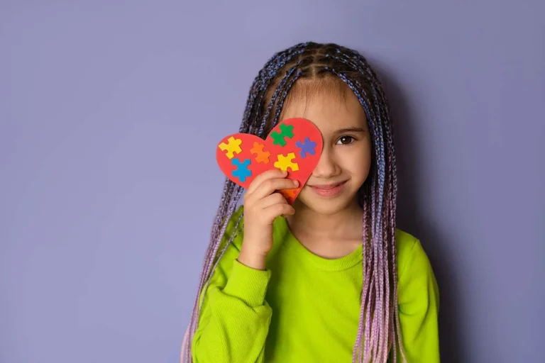 female child standing with heart shaped toy demonstrating tips for parents with children diagnosed with autism